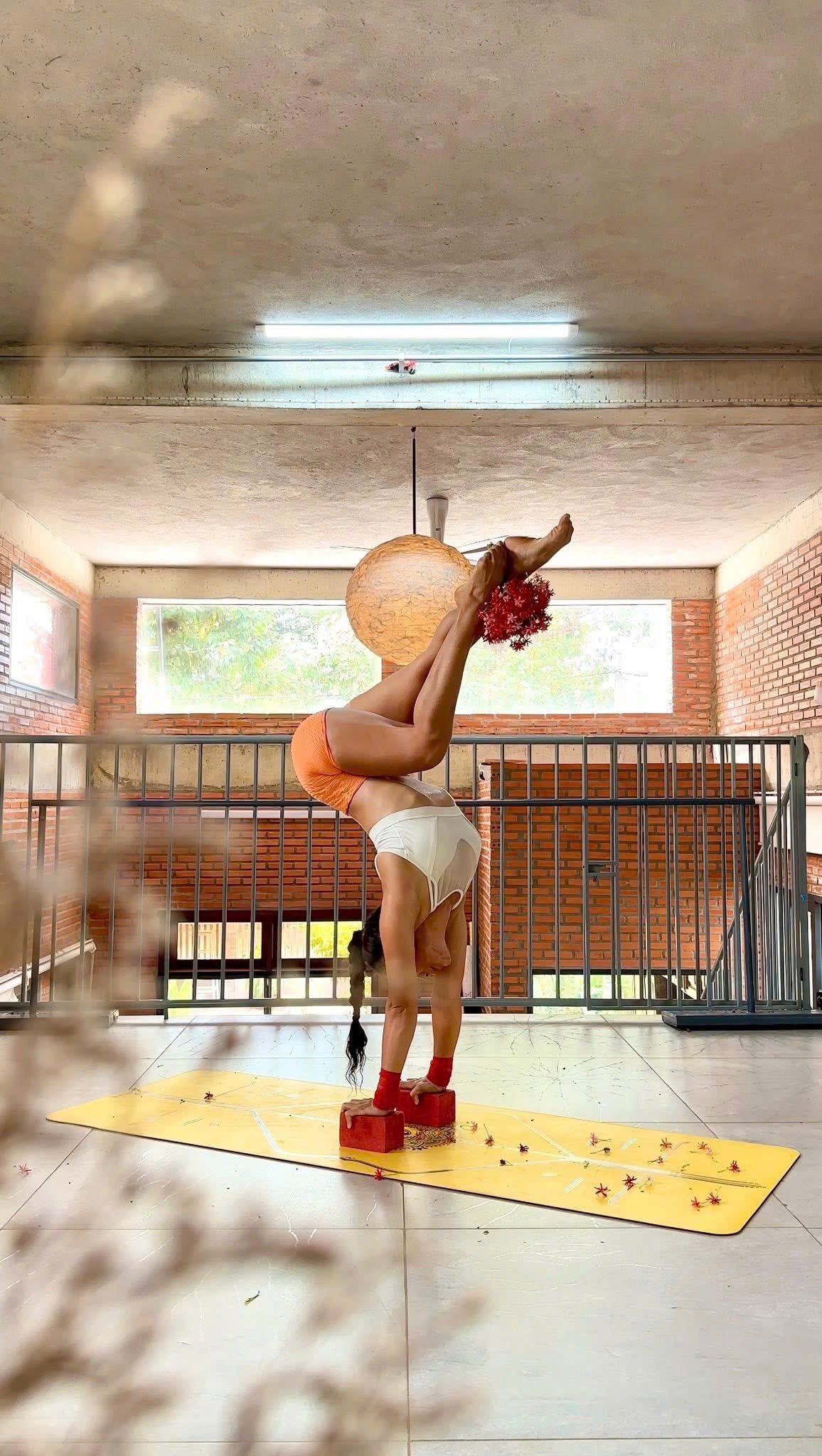 Yoga handstand with red flowers