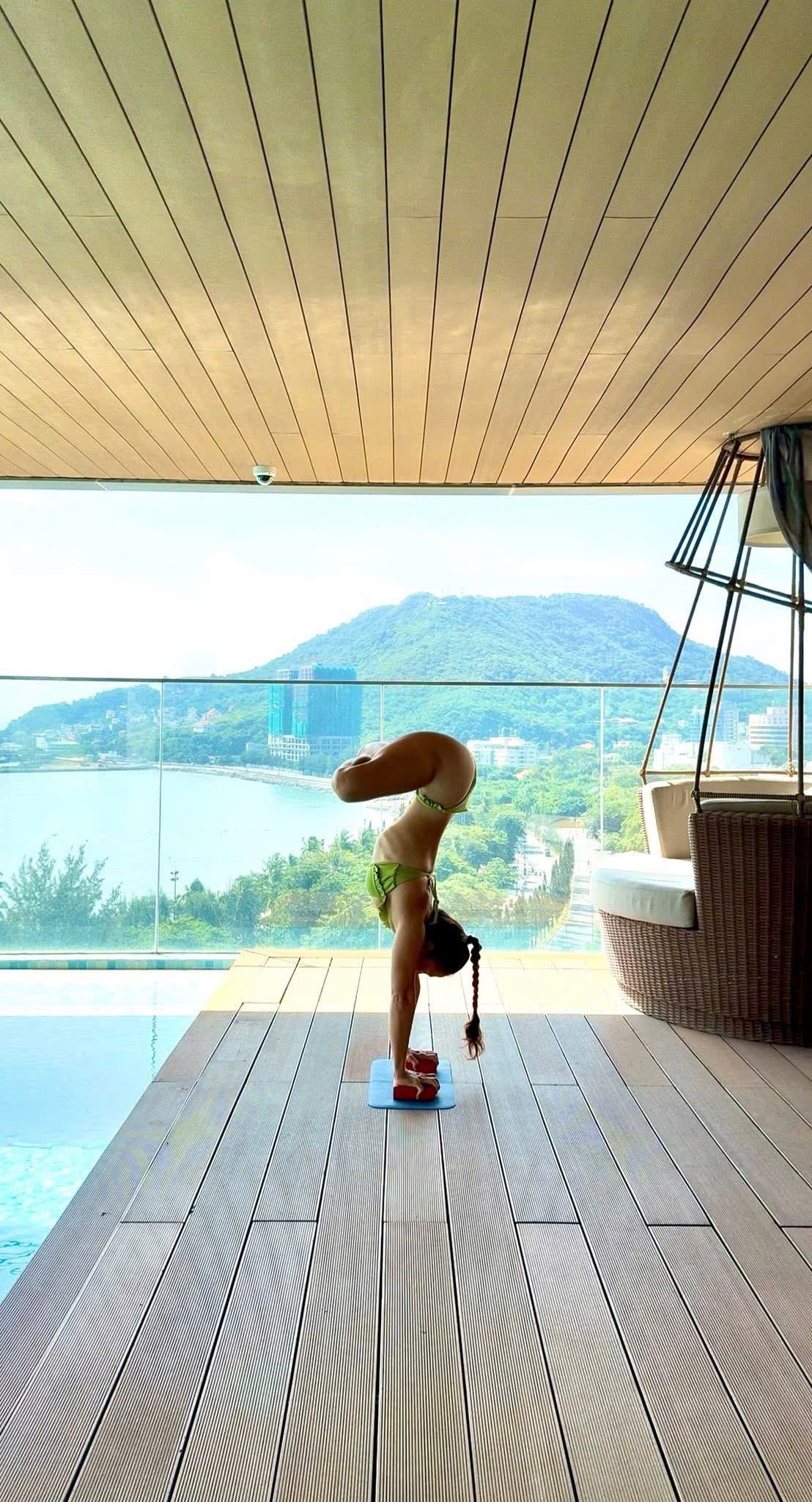 Handstand by the pool with mountain view